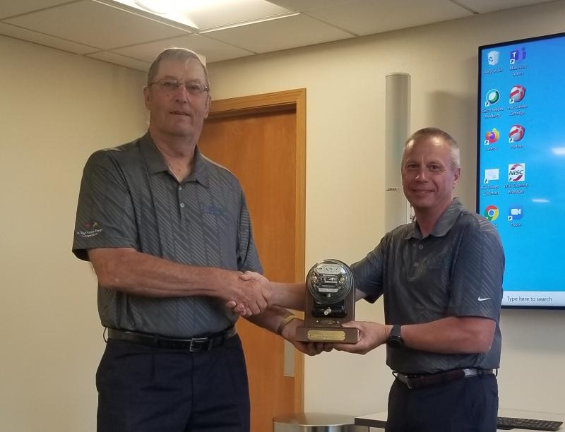 Allen Albers (left) and Steve Rau (right) shake hands and hold award
