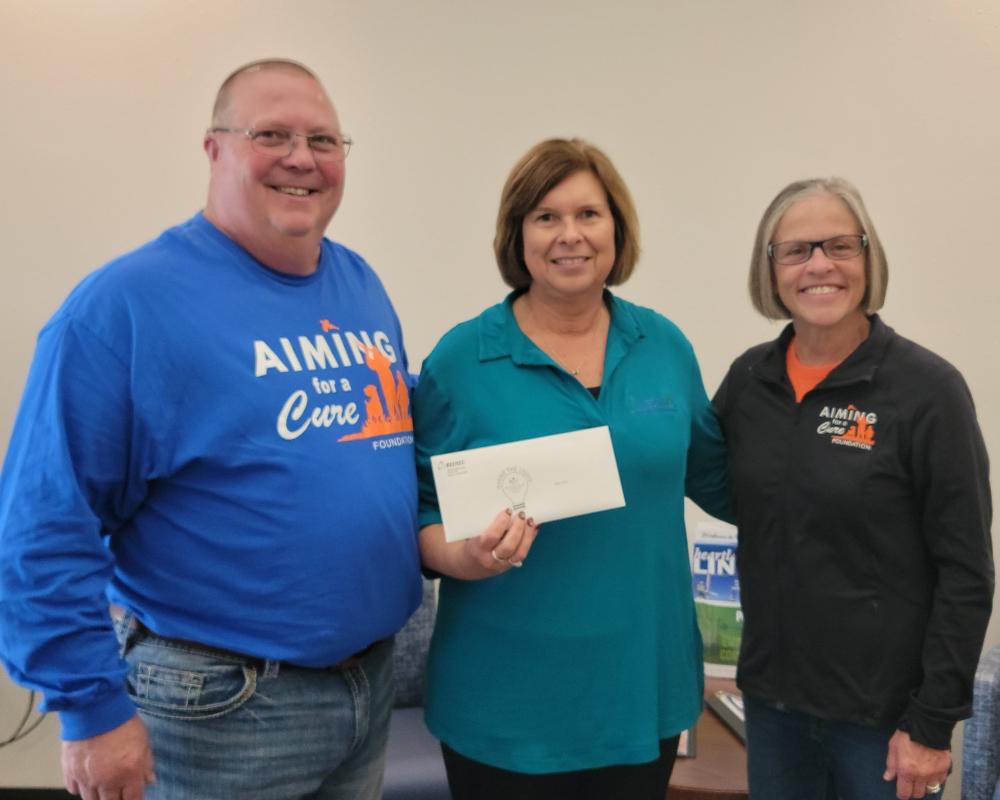 Steve and Jodie Ries receiving check from Teresa Floyd